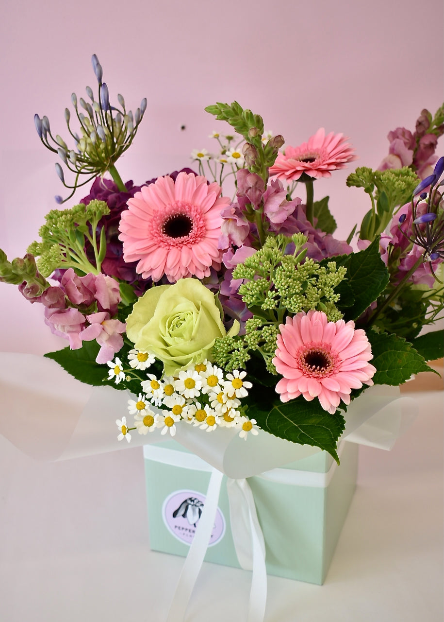 Pastel coloured fresh flowers in a sage green box. Roses, hydrangea, gerbera &amp; daisies in shades of white, green, pink and pastel purple